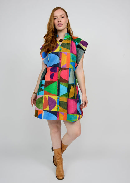 Woman wearing a colorful geometric patterned dress on a white background