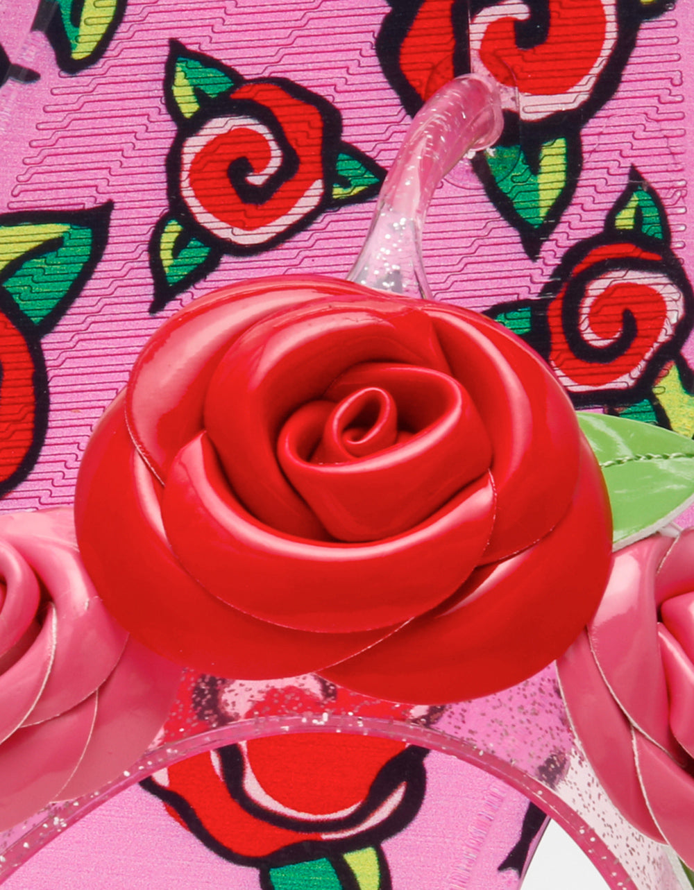 Close-up of a red rose-shaped object on a pink background with floral patterns