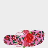 Pink sandal with floral design and red rose on a white background