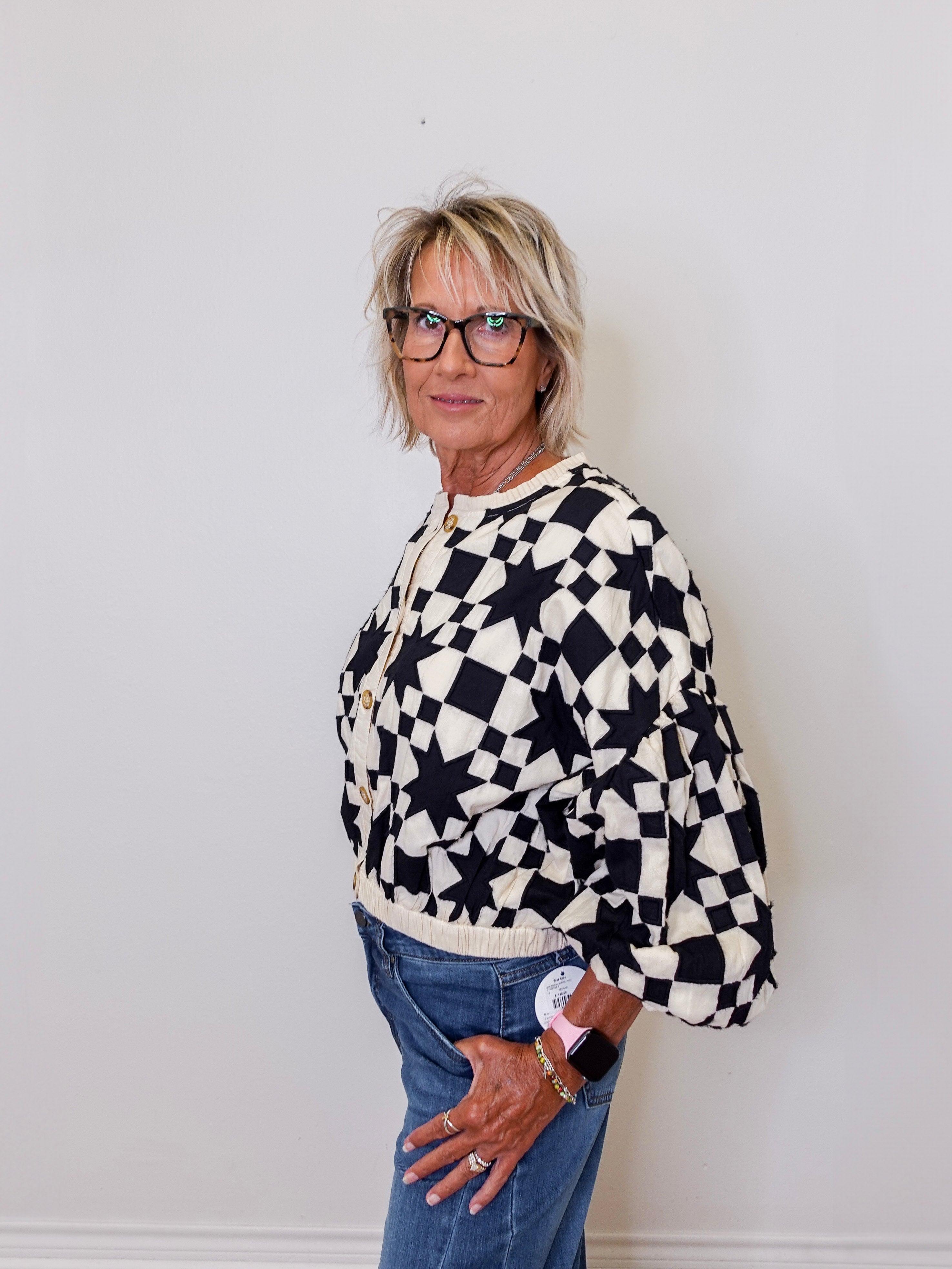 Person wearing a black and white checkered sweater against a plain background