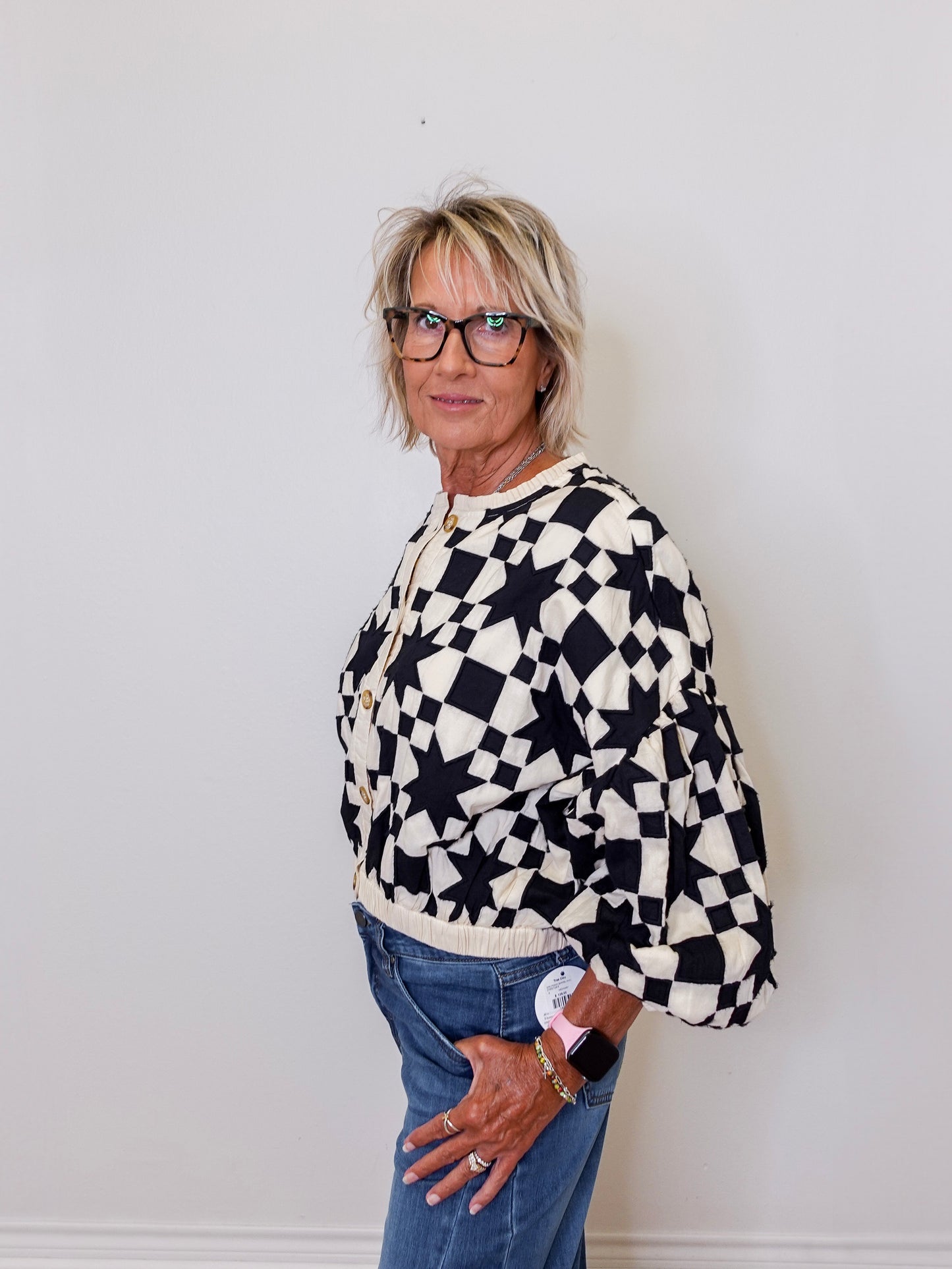 Person wearing a black and white checkered sweater against a plain background