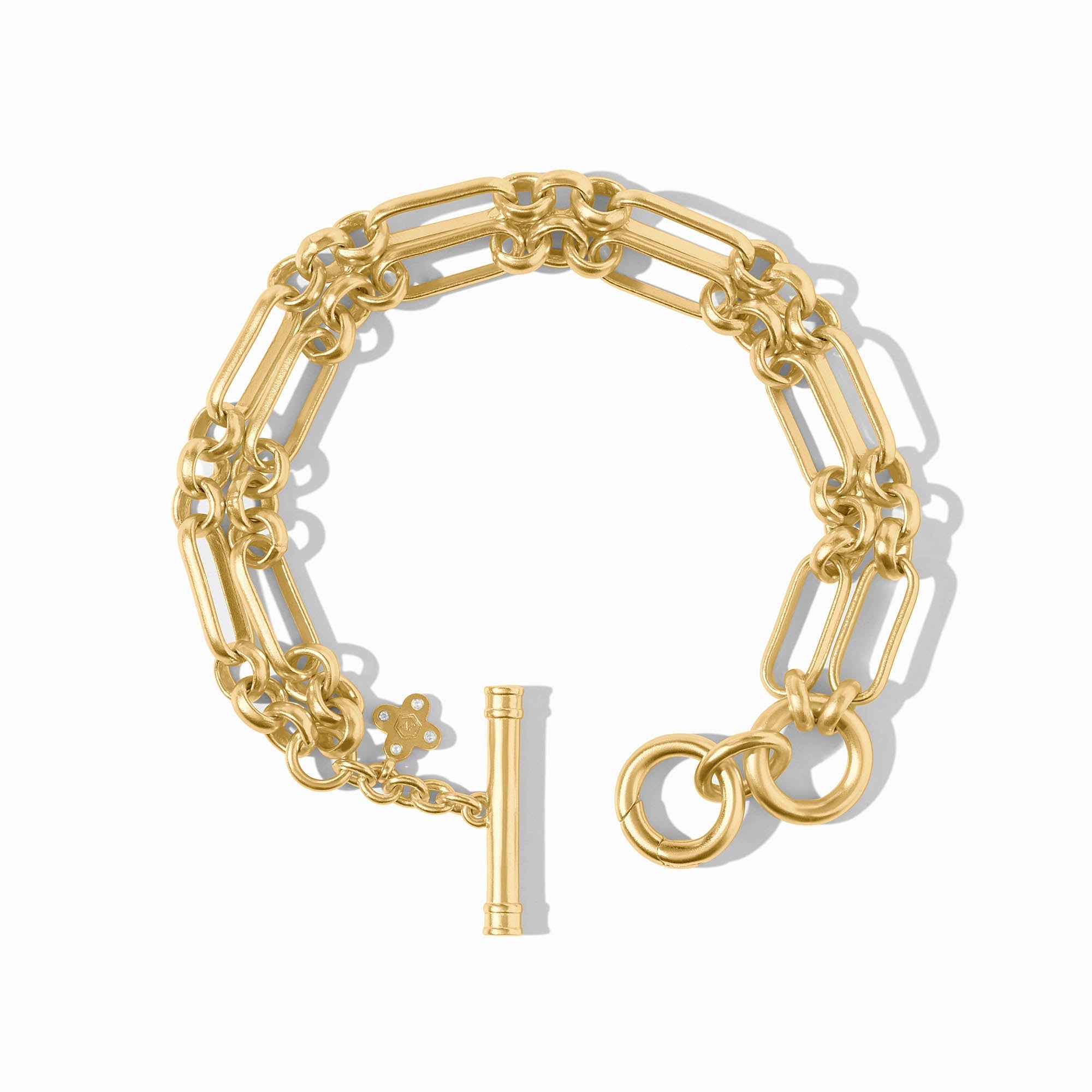 Gold bracelet with a floral charm on a white background