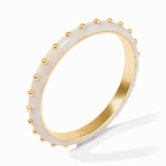 Gold ring with white ceramic band featuring gold studs on a white background