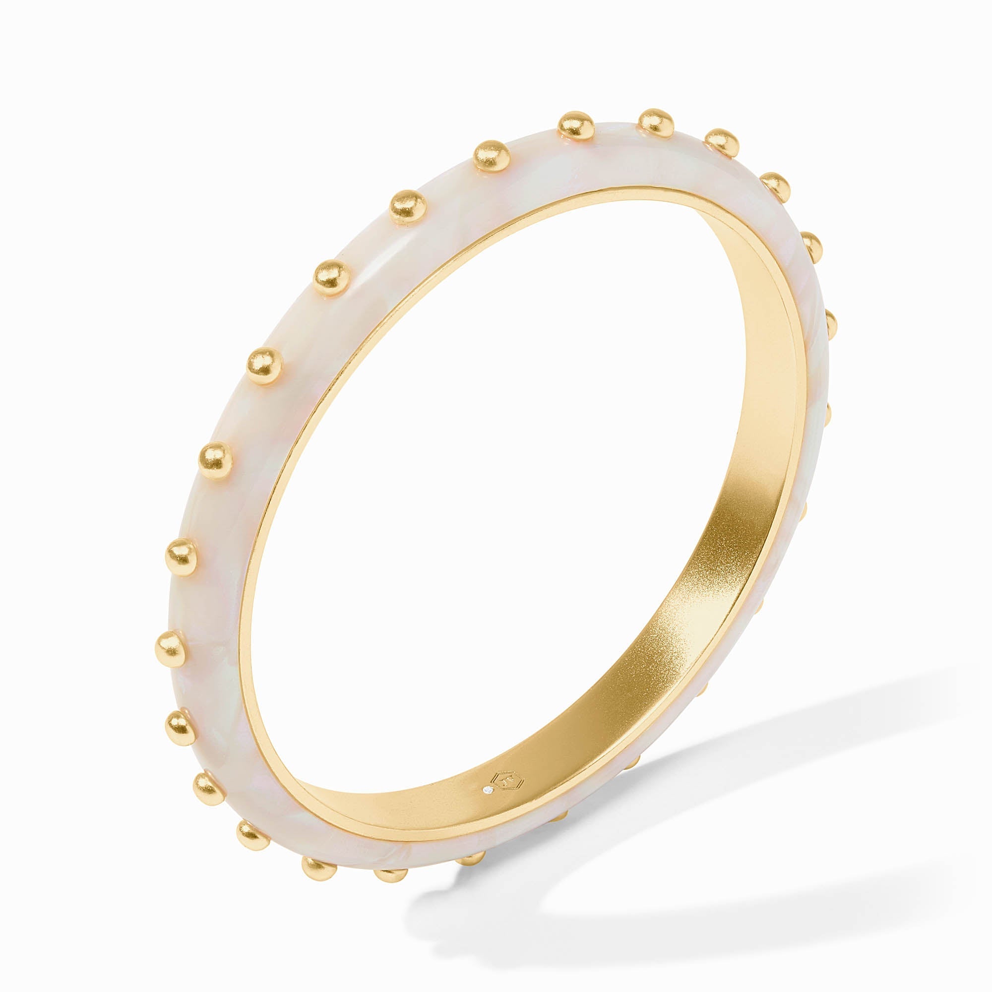 Gold ring with white ceramic band featuring gold studs on a white background