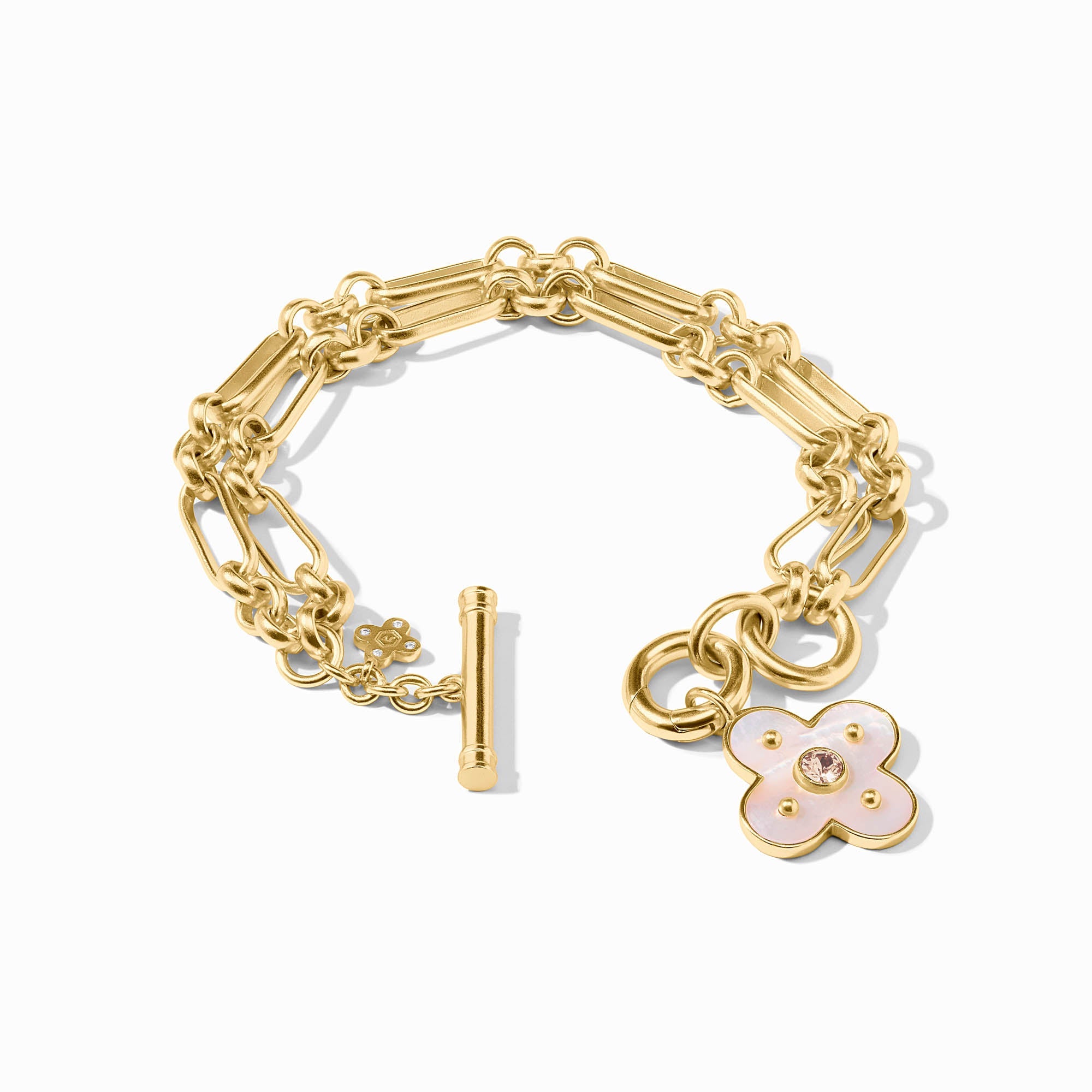 Gold bracelet with a floral charm on a white background