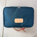 Blue toiletry bag with beige patch on a light surface