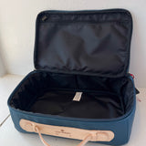 Open blue suitcase with beige handle on a white surface