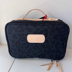 Black leopard print toiletry bag with beige accents on a white surface