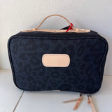 Black leopard print toiletry bag with beige accents on a white surface