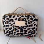 Leopard print travel bag on a white surface with a white background