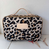 Leopard print travel bag on a white surface with a white background