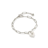 Silver chain bracelet with a heart padlock charm on a white background