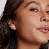 Close-up of a woman wearing a diamond earring with a plain background
