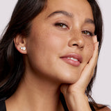 Woman wearing a heart-shaped earring with a plain background