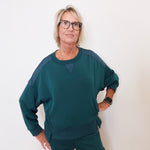 Person wearing a teal outfit against a white background