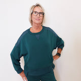 Person wearing a teal outfit against a white background