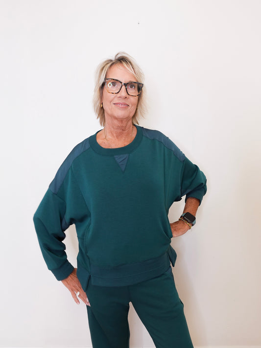 Person wearing a teal outfit against a white background