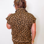 Person wearing a leopard print outfit against a white background