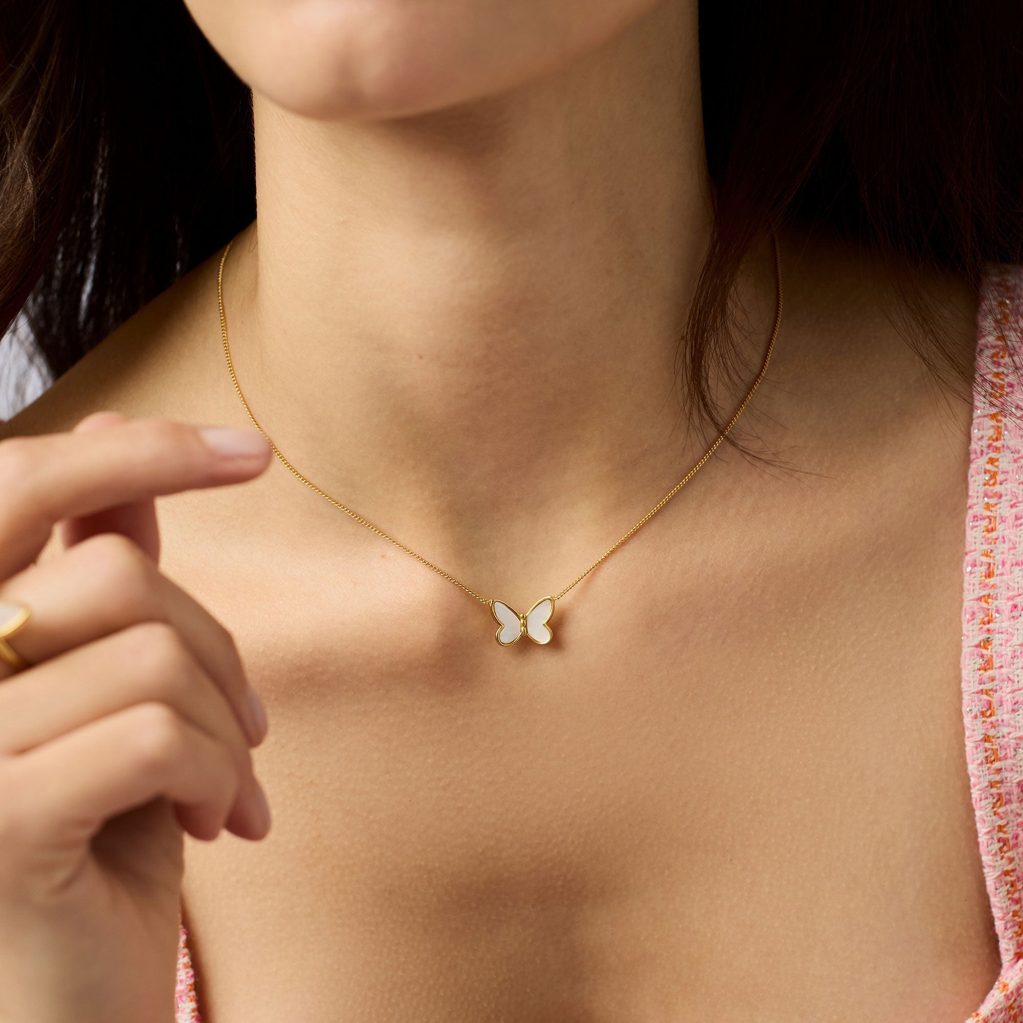Butterfly necklace worn by a person with a blurred background