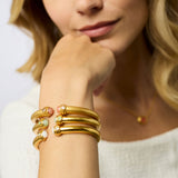 Woman wearing gold bracelets on a white background