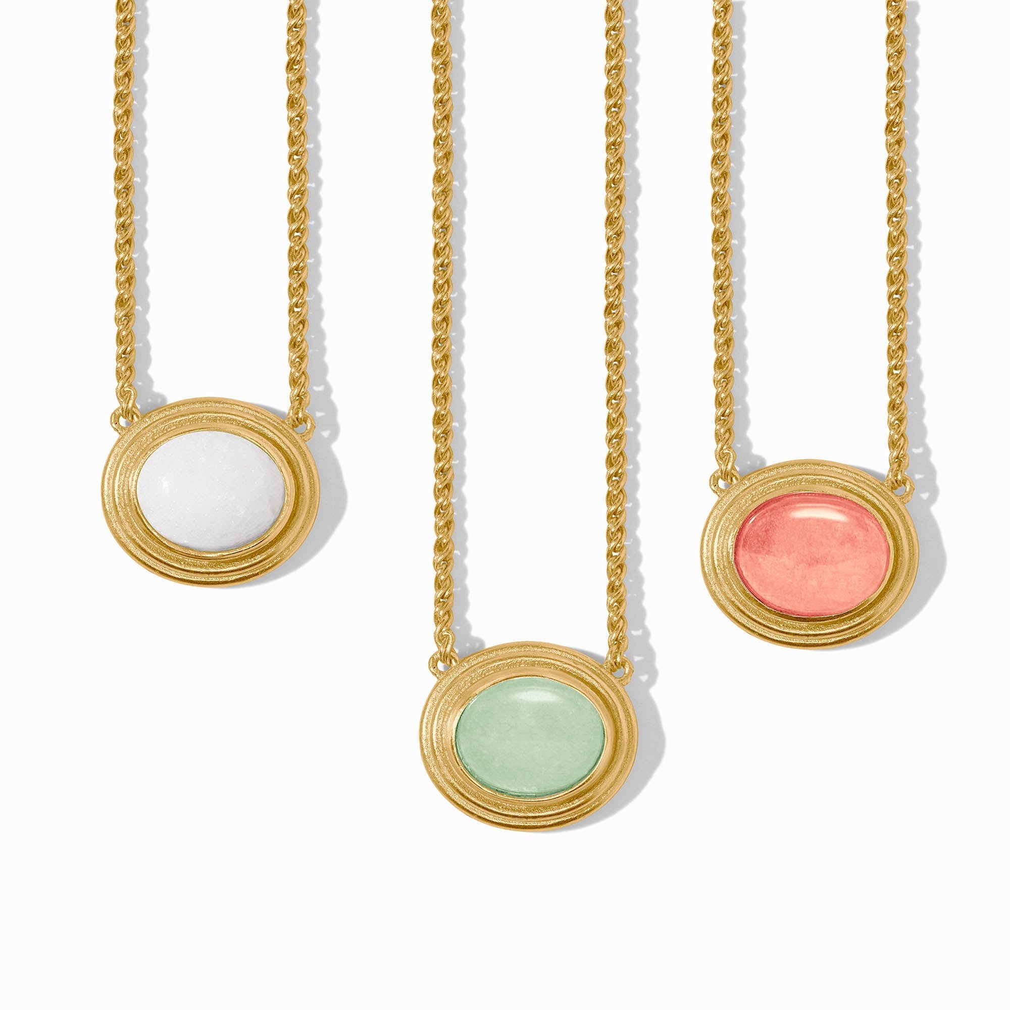 Three gold necklaces with round stone pendants on a white background
