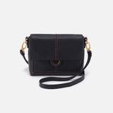 Black leather crossbody bag with gold accents on a white background