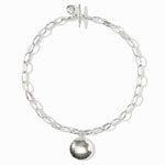 Silver chain bracelet with a round pendant on a white background