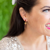 Close-up of a woman wearing a gold earring with a green blurred background