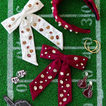 Accessories including headbands and hair bows on a football field background