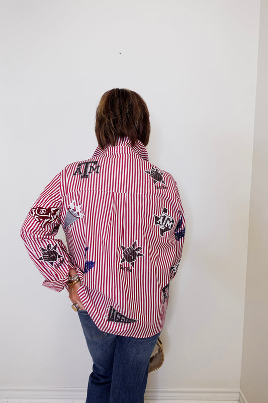 Person wearing a red and white striped shirt with black designs against a white wall
