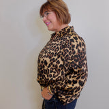 Woman wearing a leopard print shirt against a plain background
