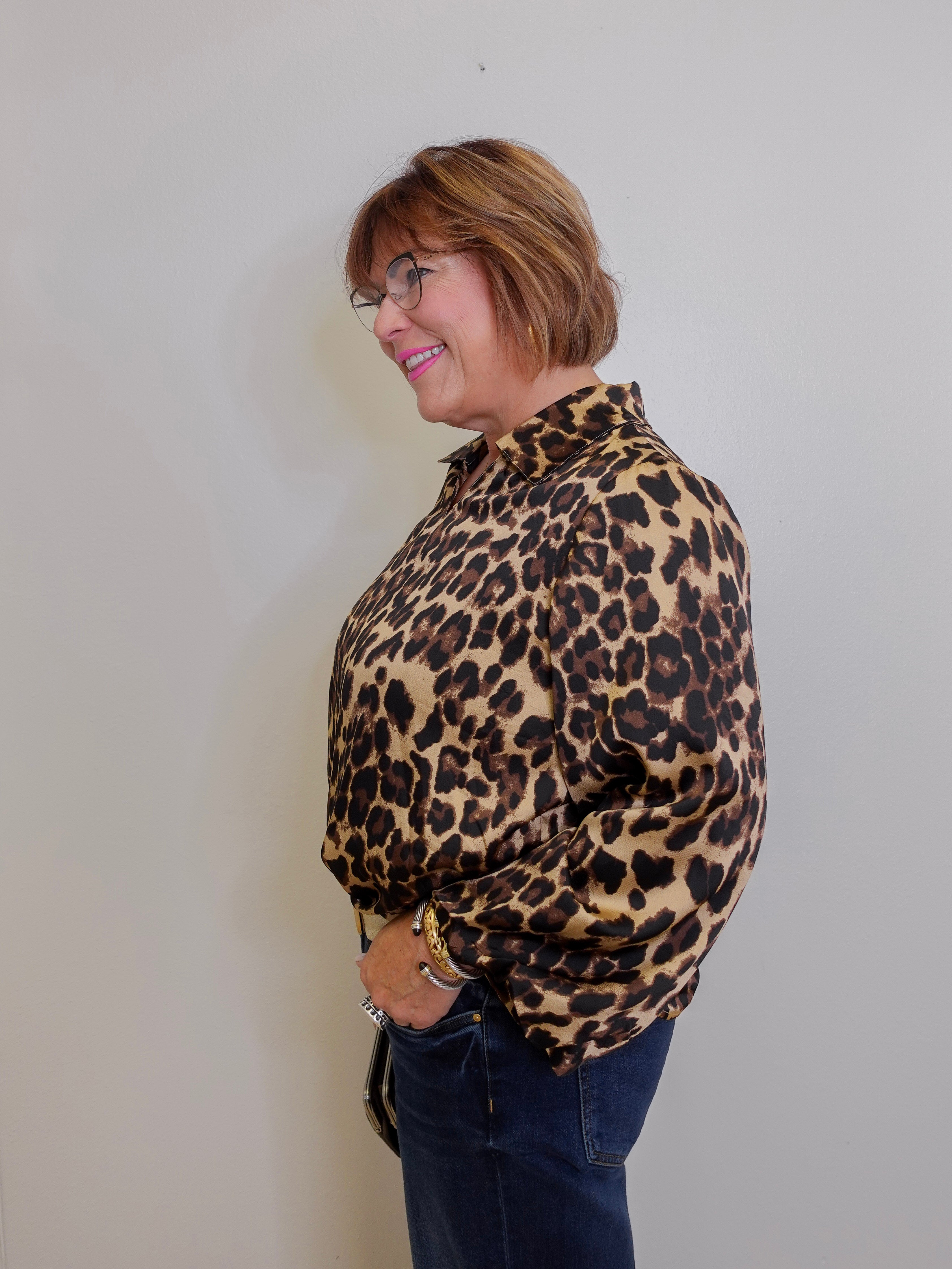 Woman wearing a leopard print shirt against a plain background