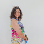 Woman wearing a colorful sleeveless top with a white background