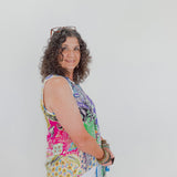 Woman wearing a colorful sleeveless top with a white background