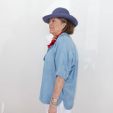 Person wearing a blue hat and light blue shirt against a white background