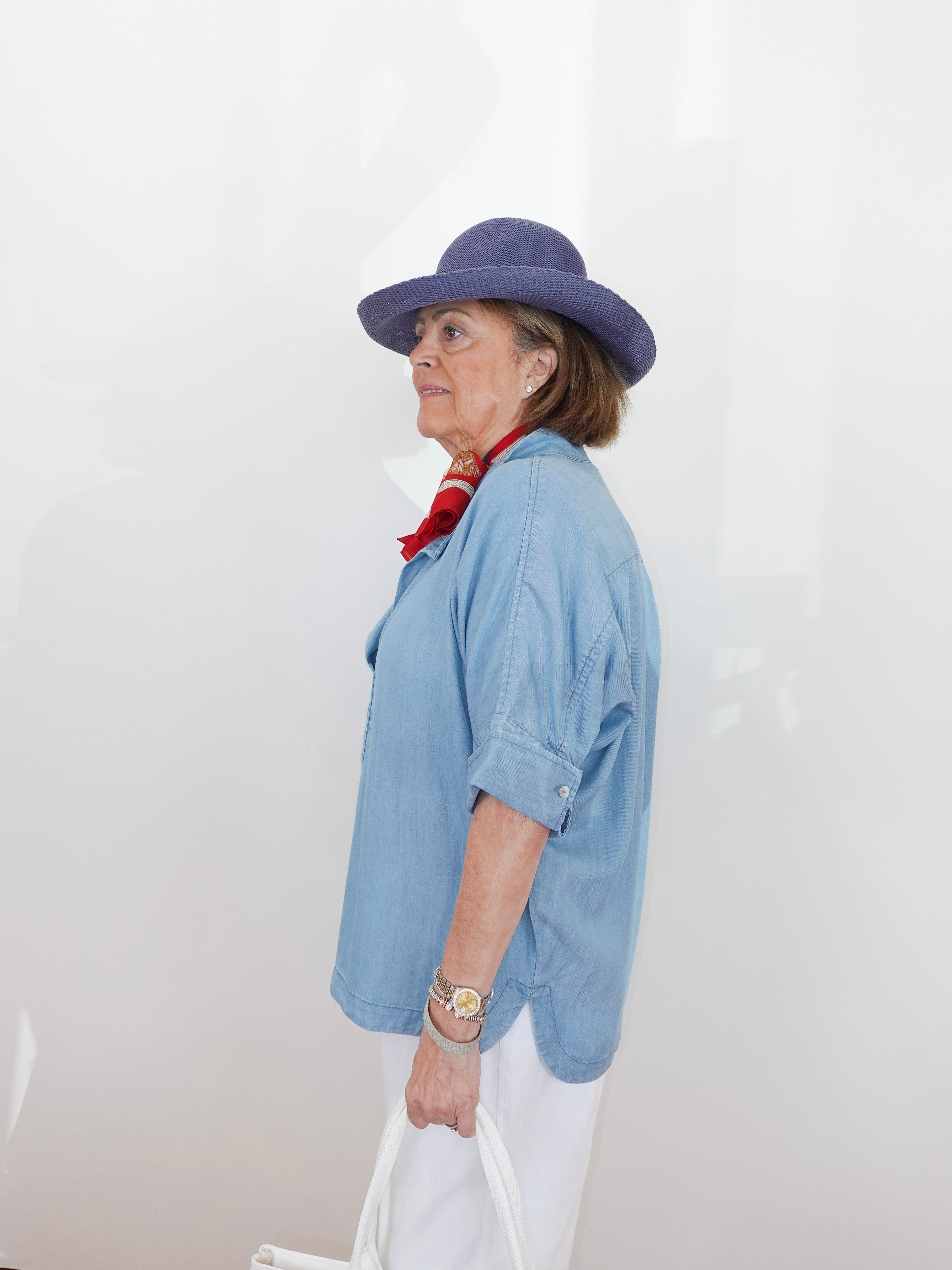 Person wearing a blue hat and light blue shirt against a white background