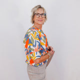 Person wearing a colorful floral shirt against a white background