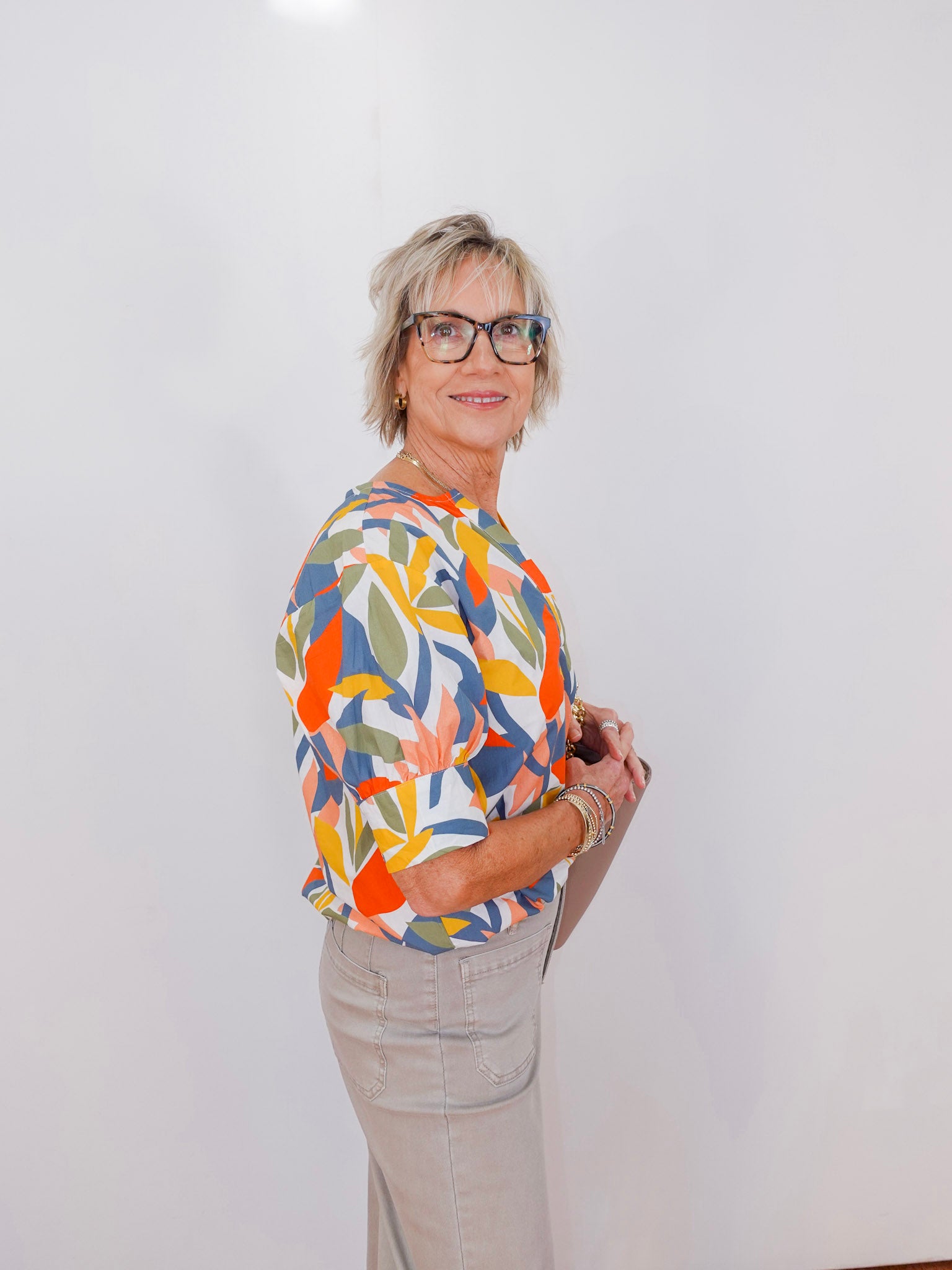 Person wearing a colorful floral shirt against a white background