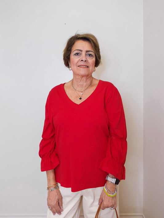Woman wearing a red blouse against a plain background