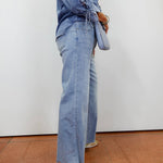 Woman wearing the APNY wide leg crop with raw edge hem in a light denim wash.
