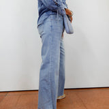 Woman wearing the APNY wide leg crop with raw edge hem in a light denim wash.