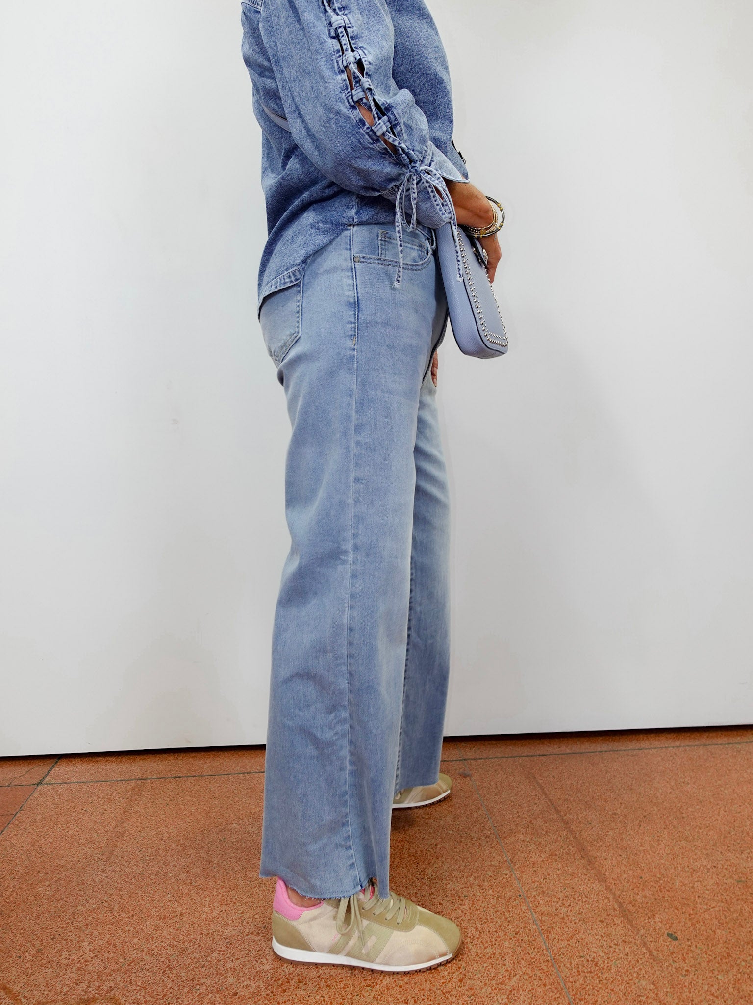Woman wearing the APNY wide leg crop with raw edge hem in a light denim wash.