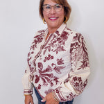 Woman wearing a patterned blouse with a plain background