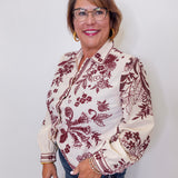 Woman wearing a patterned blouse with a plain background