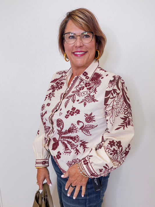 Woman wearing a patterned blouse with a plain background