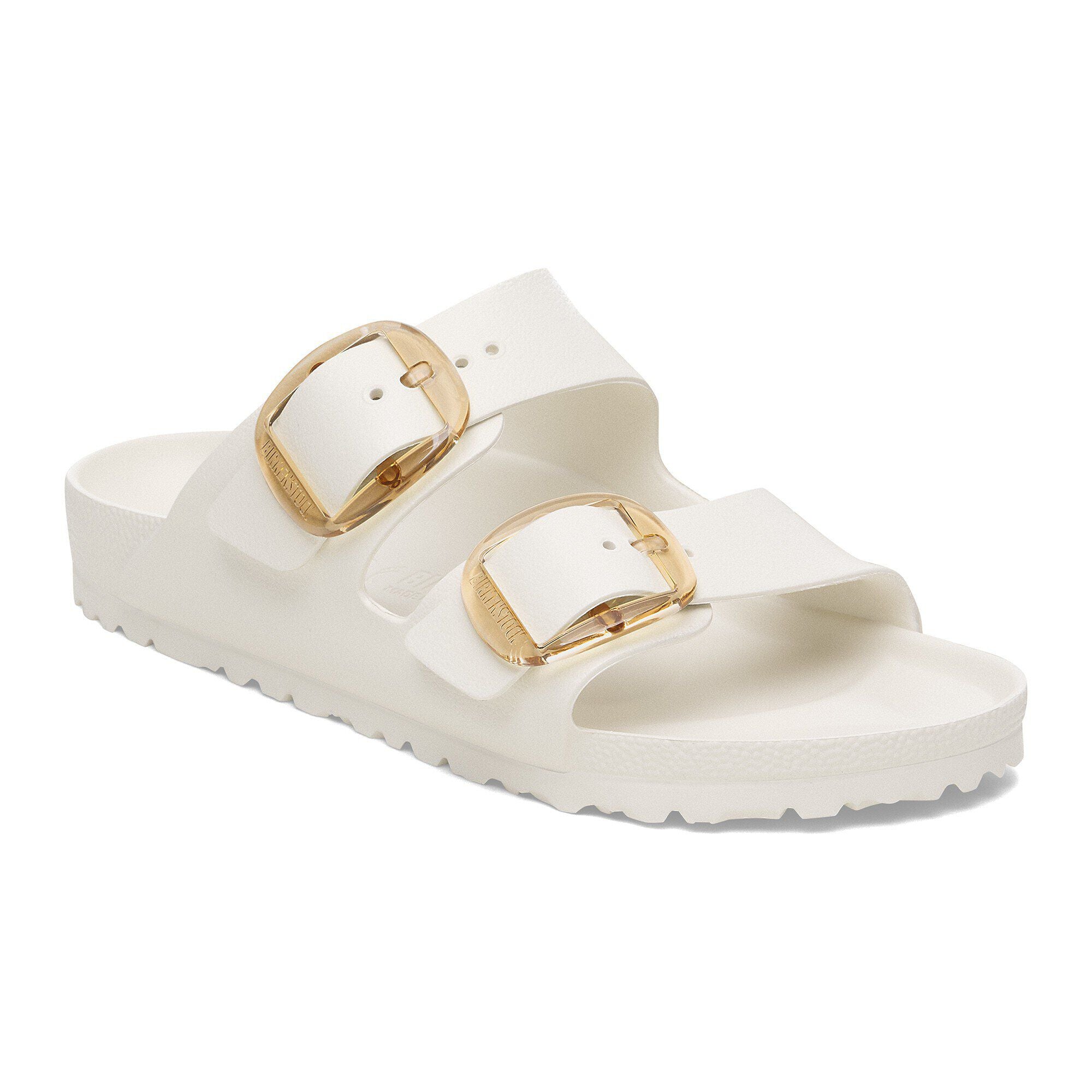 White sandal with gold buckles on a white background