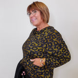 Woman wearing a leopard print sweater against a plain background