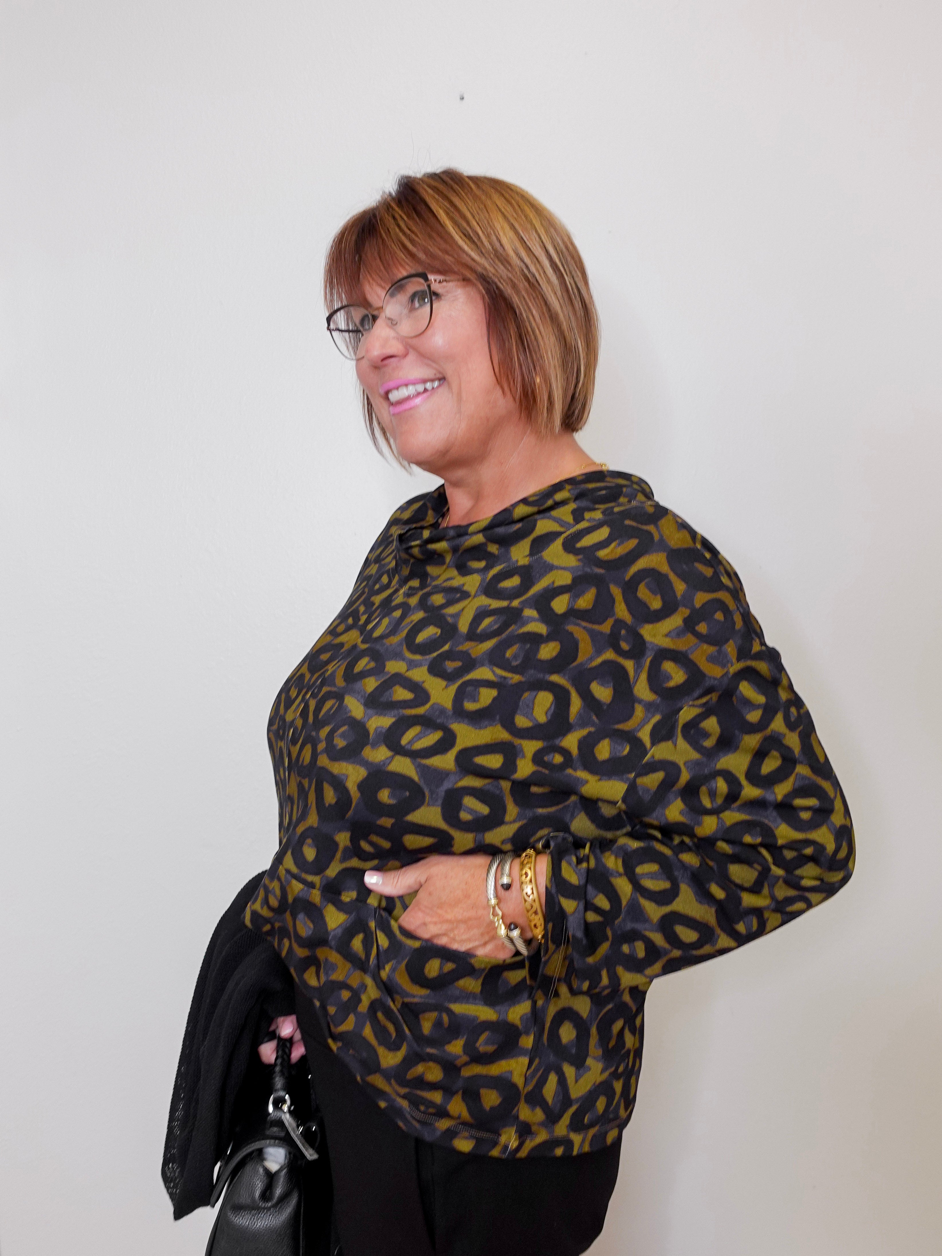 Woman wearing a leopard print sweater against a plain background