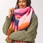 Woman wearing a colorful scarf and green jacket on a white background