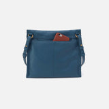 Blue handbag with a brown phone case on a white background